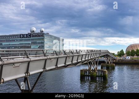 Die Millenium Bridge über den Fluss Clyde mit dem Fernseh- und Radiohauptsitz der BBC Scotland und dem Glasgow Science Center im Hintergrund. Stockfoto