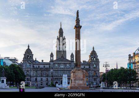 Sir Walter Scott Monument auf dem George Square mit den großartigen City Chambers im Hintergrund, Glasgow City Centre, Schottland. Stockfoto