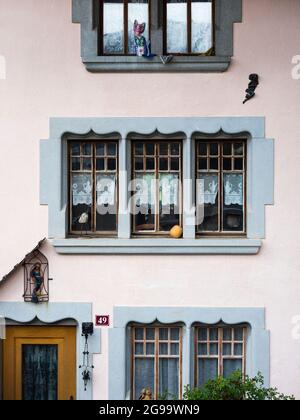 Verzierte Fenster und Fassade eines traditionellen Schweizer Gebäudes im historischen Schweizer Dorf Gruyere (Kanton Freiburg) Stockfoto