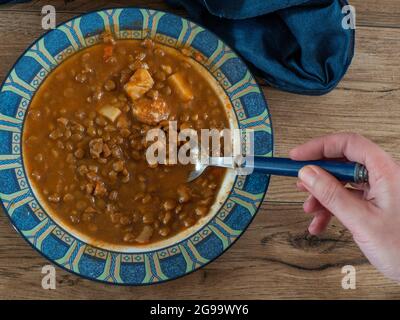 Linsensuppe auf einem Teller auf Holzhintergrund Stockfoto