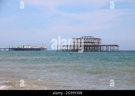 Brighton Piers umgeben von einem ruhigen Meer an einem Sommertag Stockfoto