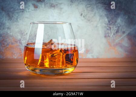 Glas Whisky mit Eis. Stillleben. Brandy, Bourbon auf einem braunen Holztisch. Starker Alkoholkonsum. Rum, Scotch. Platz für Text kopieren
