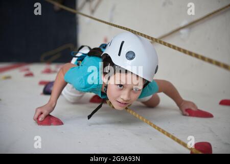 Mädchen klettern an der Kletterwand in London Stockfoto