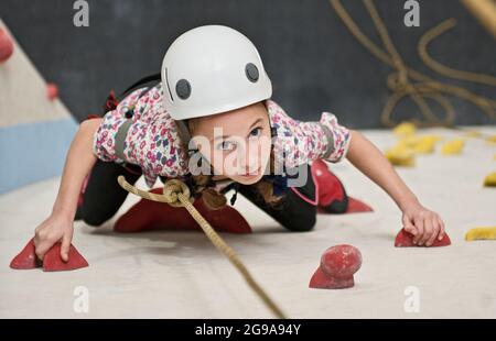 Mädchen klettern an der Kletterwand in London Stockfoto