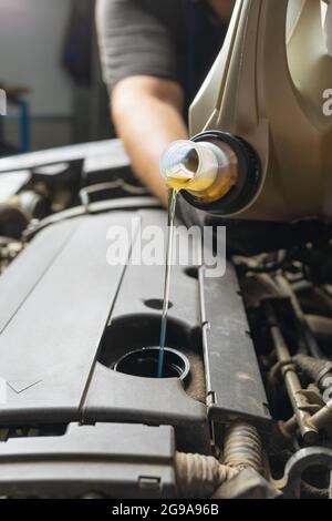 Ein Automechaniker gießt Motoröl aus nächster Nähe Stockfoto