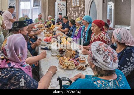 Bewohner eines sibirischen Dorfes feiern den muslimischen Feiertag Kurban Bayram an ihrem Heimattisch. Eid al-Adha, das Opferfest. Stockfoto
