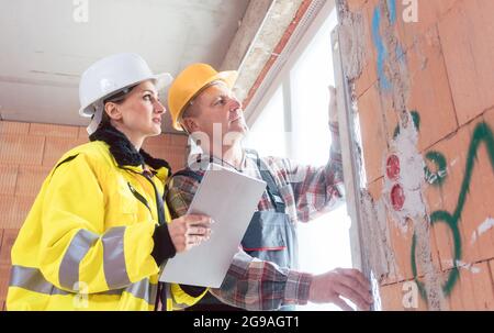 Bauarbeiter und Ingenieur, der die Fensterscheibe überprüft Stockfoto