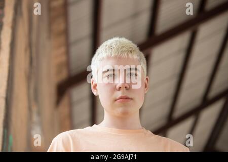 Porträt eines Teenagers mit gebleichtem Haar, der von unten auf die Kamera schaut Stockfoto