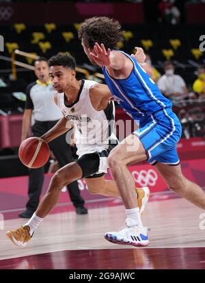 (210725) -- TOKIO, 25. Juli 2021 (Xinhua) -- Maodo Lo (L) aus Deutschland bricht während der Männer-Basketball-Pool-Runde zwischen Deutschland und Italien in Tokio, Japan, am 25. Juli 2021 durch. (Xinhua/Meng Yongmin) Stockfoto