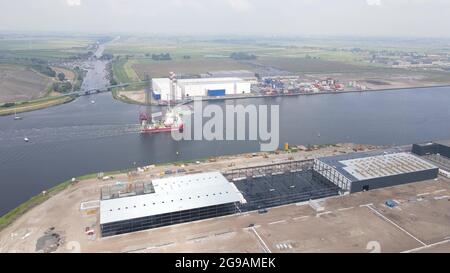 Luftdrohnenansicht einer Plattform mit einem Kran auf der Oberseite, der durch den Amsterdamer Westpoort, Niederlande, segelt. Stockfoto