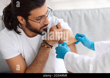 Junger Mann aus dem Nahen Osten wird gegen das Coronavirus beschossen Stockfoto