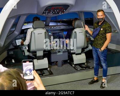 Schukowski, Russland. Juli 2021. Besucher fotografieren das Cockpit des Flugsimulators mit ihren Handys. Ein umfangreiches Programm für die 15. MAKS Air Show wurde von den Kunstflugteams "Russian Knights", "Swifts", "Falcons of Russia" und "berkuts" vorbereitet, die die Luftwaffe der Russischen Föderation repräsentieren. Die Piloten des russischen First Flight Kunstflugteams und natürlich die Gäste aus Indien - das SARANG Hubschrauber Kunstflugteam - nahmen ihr Flugzeug über Schukowski in den Himmel. (Foto von Mihail Siergiejevicz/SOPA IMAG/Sipa USA) Quelle: SIPA USA/Alamy Live News Stockfoto