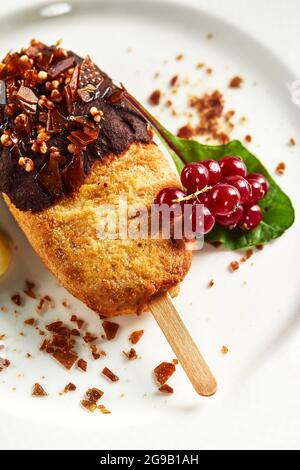 Chicken Kiew mit Kartoffelpüree und einem Zweig roter Johannisbeeren auf einem hellen Teller, weißer Hintergrund Kopie Space, die ursprüngliche Lieferung von Kiewer Koteletts Stockfoto