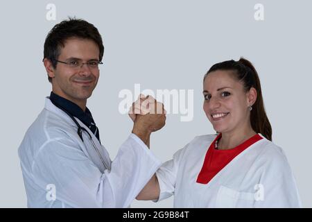 Arzt und Krankenschwester umarmen sich gegenseitig und lächeln vor der Kamera. Konzept der Zusammenarbeit zwischen Arzt und Krankenschwester. Stockfoto
