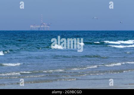 Ameland, Niederlande April 20,2021-NAM, Ölplattform, Offshore-Plattform mit Strand, Sand und Surfen. Erdgasförderung im Wattenmeer-Nordseeraum Stockfoto