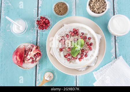 Nahaufnahme einer Schüssel Hirsegrieß mit Granatapfelkernen Stockfoto