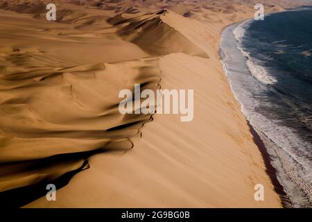 Luftaufnahme von Sandwich Harbour, wo die Namib-Wüste auf die Atlantikküste trifft, in der Nähe der Walvisbucht in Namibia, Afrika. Stockfoto