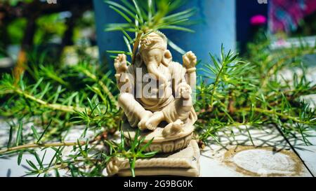 Gott der Weisheit und des Wohlstands. Lord Ganesha Figur neben dem Fenster mit Blick auf den Park Stockfoto