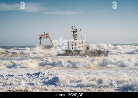 Wellen schlagen auf das Zeila Shipwreck an der Skeleton Coast in Namibia, Südwestafrika. Stockfoto