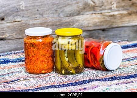 Eine Nahaufnahme von Gläsern mit eingelegten roten Paprika und eingelegten Gurken Stockfoto