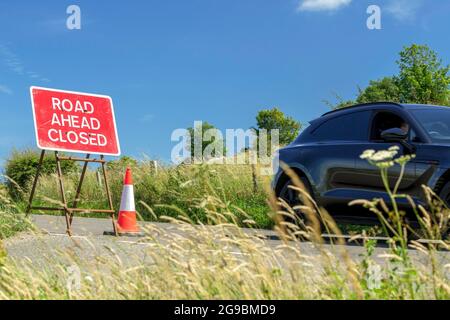 Das Auto passiert das Schild, da die Straße vor dem Hotel in Großbritannien gesperrt ist Stockfoto