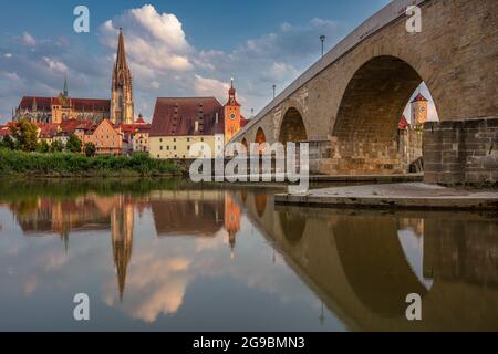 Regensburg, Deutschland. Stadtbild von Regensburg, Deutschland mit der alten Steinbrücke über die Donau und dem Petersdom bei Sonnenuntergang im Sommer. Stockfoto