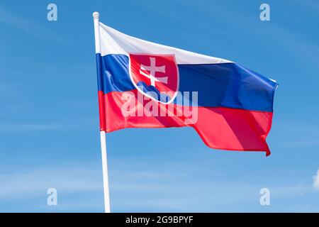 Flagge der Slowakei auf blauem Himmel Hintergrund. Slowakische Flagge winkt bei Wind und Sonnenlicht Stockfoto