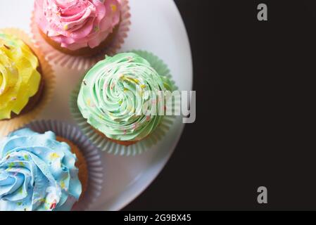 Bunte Cupcakes auf schwarzem Hintergrund Stockfoto