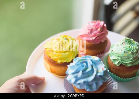 Bunte Muffins auf weißem und grünem Hintergrund Stockfoto