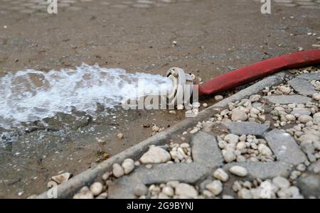 Wasserschaden - Wasser wird nach heftigen Regenfällen aus einem überfluteten Keller in Köln gepumpt. Stockfoto