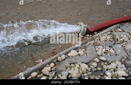 Wasserschaden - Wasser wird nach heftigen Regenfällen aus einem überfluteten Keller in Köln gepumpt. Stockfoto