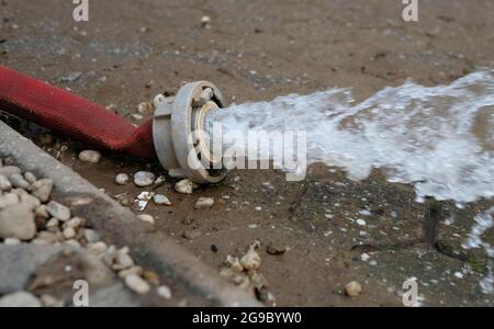 Wasserschaden - Wasser wird nach heftigen Regenfällen aus einem überfluteten Keller in Köln gepumpt. Stockfoto