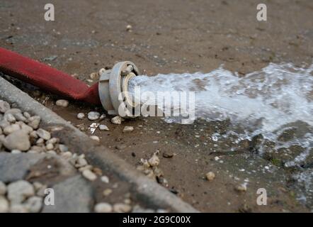 Wasserschaden - Wasser wird nach heftigen Regenfällen aus einem überfluteten Keller in Köln gepumpt. Stockfoto