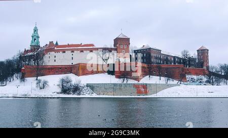 Krakau, Polen 03.02.2021 Panoramablick auf die Altstadt von Krakau, Polen mit der Weichsel im Vordergrund. Die Stadt ist mit Schnee bedeckt. Tagesaufnahme während der Wintersaison. Stockfoto