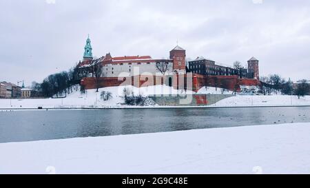 Krakau, Polen 03.02.2021 Panoramablick auf die Altstadt von Krakau, Polen mit der Weichsel im Vordergrund. Die Stadt ist mit Schnee bedeckt. Tagesaufnahme während der Wintersaison. Stockfoto