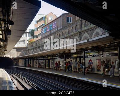 London, Greater London, England, 12 2021. Juni: Menschen warten auf einem Bahnsteig an der U-Bahnstation Sloane Square oder der U-Bahn-Station. Stockfoto