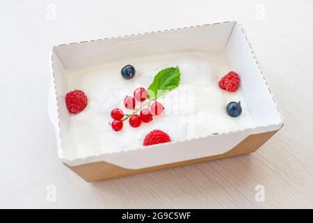 Ein erfrischendes Dessert aus Savoyardi, Grapefruitmarmelade und Sauerrahm mit Himbeeren und Johannisbeeren. Stockfoto