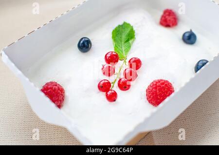 Ein erfrischendes Dessert aus Savoyardi, Grapefruitmarmelade und Sauerrahm mit Himbeeren und Johannisbeeren. Stockfoto