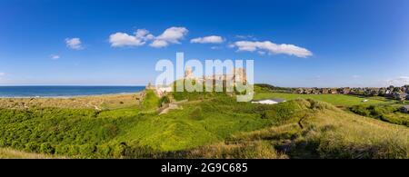 Panoramablick auf Bamburgh Castle mit Strand und Cricket-Feld an der Nordostküste Englands, neben dem Dorf Bamburgh in Northumberland Stockfoto