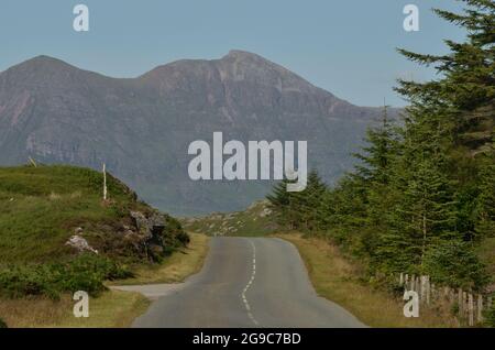 Die A837, eine Crofter County Road direkt außerhalb von Lochinver in den schottischen Highlands, Großbritannien. Der Berg dahinter ist Quinag. Stockfoto