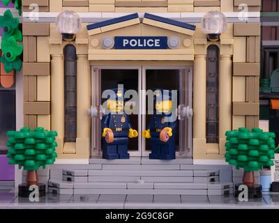 Tambow, Russische Föderation - 02. Juli 2021 zwei Lego-Polizisten, die vor ihrer Polizeistation stehen und Donuts essen. Stockfoto