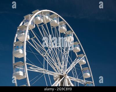 An einem sonnigen Sommertag gegen einen tiefblauen Himmel, das weiße Stahlwerk und die Gondeln der Riesenrad-Touristenattraktion in Portrush an der Antrim-Küste Stockfoto