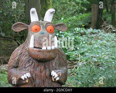 Fiktive Figur der Gruffalo als Holzskulptur auf einem kinderfreundlichen Spaziergang im Wald bis zum Aussichtspunkt am Orrest Head, Lake Windermere. Stockfoto