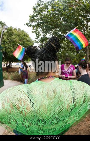 Atlanta, GA, USA - 12. Oktober 2019: Eine Frau trägt zwei kleine Gay Pride Flaggen im Haar, bevor sie an der Atlanta Transgender Parade teilnimmt. Stockfoto