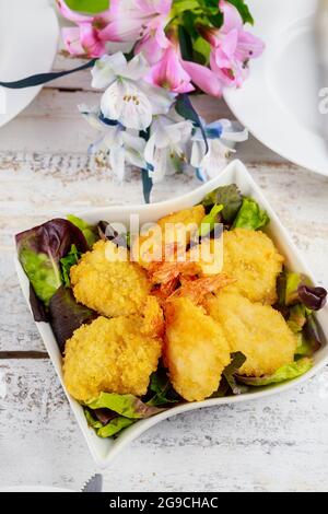Frittierte panierte Garnelen mit grünem Salat und Tischset. Stockfoto