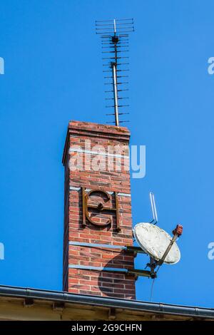 Dekorative „Chainage“-Verstärkungsbinde, die einen hohen Ziegelschornstein stützt - Richelieu, Indre-et-Loire, Frankreich. Stockfoto