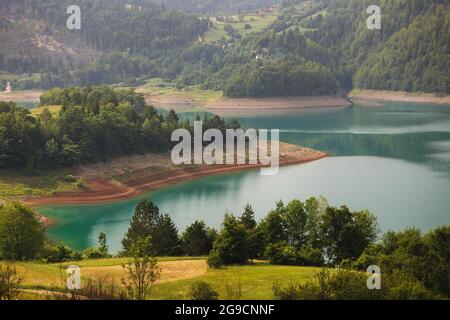 Schöne Aussicht auf Bergsee und Felder in nebligen Sommermorgen. Natur im Freien Reiseziel, Nationalpark Tara, Zaovine See, Serbien Stockfoto