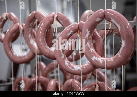 Die Wurst auf der Fleischfabrik für das Rauchen vorbereitet. Herstellung von Delikatessen. Würste (Sucuk) im Werkslager. Produktionslinie für Wurst. Indust Stockfoto