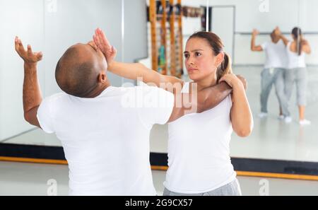 Frau und Mann beim Selbstschutztraining, Training der Angriffsbewegungen Stockfoto