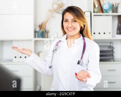 Ärztin in Uniform, die in die Arztpraxis einlädt Stockfoto